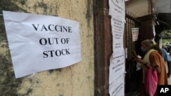 FILE - A note about the non-availability of COVID-19 vaccine is seen pasted on a wall of a vaccination site in Mumbai, India, April 8, 2021. 