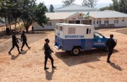 FILE - Rwandan police guard the van carrying Paul Rusesabagina as it arrives at the Kicyikuri primarily court in Kigali, Rwanda, Sept. 14, 2020.
