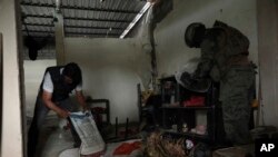 Un policía y un soldado buscan drogas y armas durante una operación conjunta en un barrio de Durán, Ecuador, el 1 de febrero de 2024.