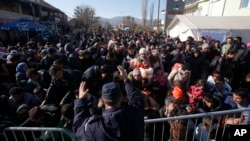 Serbian police officer attempt to organise migrants queuing to get registered at a refugee center in the southern Serbian town of Presevo, Monday, Nov. 16, 2015. 
