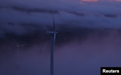 FILE - Wind turbines are surrounded by fog at a wind farm in the mountains of Galicia region, near Vilalba, Spain March 20, 2024. (REUTERS/Nacho Doce)