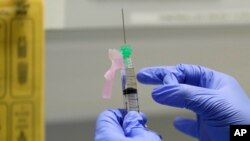 Un enfermero prepara una vacuna experimental que sería administrada a un voluntario en una clínicas en Londres.