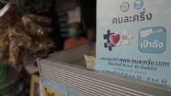 A sign for the government funded co-payment, scheme which the state picks up half hung outside a street stall in Bangkok. (Vijitra Duangdee/VOA)