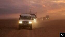 This photo released by the Syrian Arab Red Crescent, shows a convoy of vehicles of the Syrian Arab Red Crescent driving in the Syrian desert heading to Rukban camp between the Jordan and Syria borders, Nov. 4, 2018.
