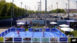 Tennis fans play a version of tennis resembling pickleball on the grounds of the Billie Jean King National Tennis Center during the first round of the U.S. Open tennis championships, Aug. 26, 2024, in New York.