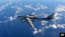 FILE - A British Royal Air Force photo shows a Russian long-range bomber flying in international airspace, Oct. 29, 2014.