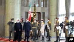 Iraqi Prime Minister Mustafa al-Kadhimi, fourth left, reviews an honor guard as he is welcomed by President Hassan Rouhani, second left, during an official arrival ceremony, in Tehran, Iran, July 21, 2020.