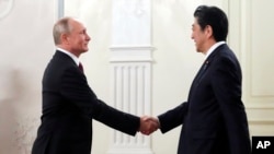 ប្រធានាធិបតី​រុស្ស៊ី Vladimir Putin និង​នាយក​រដ្ឋ​មន្ត្រី​ជប៉ុន Shinzo Abe ចាប់​ដៃ​គ្នា​នៅ​មុន​ពេល​ប្រារព​ពិធី​វប្បធម៌​រវាង​ប្រទេស​ទាំង​ពីរ​ នៅទីក្រុង​មូស្គូ ប្រទេស​​រុស្ស៊ី​កាល​ពី​ថ្ងៃ​ទី​២៦ ឧសភា ២០១៨។