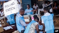 Election officials count ballot papers cast at a polling station in Freetown, Sierra Leone, March 7, 2018.