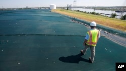 Project manager Jeff Richey, walks along the non-permeable cover of Coal Ash Basin B along the banks of the Elizabeth River in Chesapeake, Virginia, June 27, 2016. 