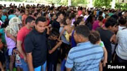 A general view shows migrants from Central America and Cuba waiting to be registered for humanitarian visas to cross the country on their way to the United States, in Acacoyagua, in Chiapas state, Mexico, March 27, 2019.