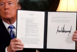 FILE - President Donald Trump holds up a proclamation declaring his intention to withdraw from the Iran nuclear agreement after signing it in the Diplomatic Room at the White House in Washington, May 8, 2018.