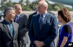 President Donald Trump's Chief of Staff John Kelly, center, speaks with Hawaii Gov. David Ige, left, and his wife, Dawn, as President Donald Trump arrives at Joint Base Pearl Harbor Hickam, Hawaii, Nov. 3, 2017.
