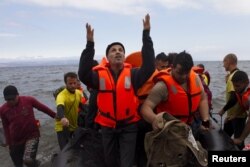 FILE - A Syrian refugee prays as he arrives on an overcrowded dinghy on the Greek island of Lesbos after crossing part of the Aegean Sea from the Turkish coast, Sept. 29, 2015.