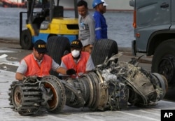 FILE - Officials inspect an engine recovered from the crashed Lion Air jet in Jakarta, Indonesia, Nov. 4, 2018. The brand new Boeing 737 MAX 8 jet plunged into the Java Sea just minutes after takeoff from Jakarta early on Oct. 29, killing all passengers on board.