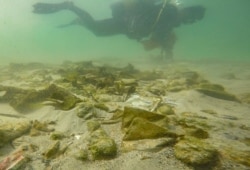 Franck Chabert, owner of the Barracuda Dive Club, pulls rubbish from the sea floor during an underwater cleanup for Earth Day in Dakar, Apr. 23, 2021.