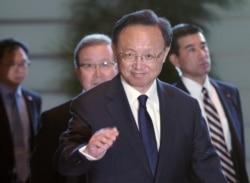 Chinese State Councilor Yang Jiechi greet media as he walks to meet Japanese Prime Minister Shinzo Abe at Abe's official residence in Tokyo, May 17, 2019.