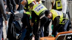 Israeli emergency services officers evacuate the body of a Palestinian assailant form the site outside Jerusalem’s Old City, Dec. 23, 2015.