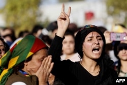 FILE - Mourners attend the funeral of a commander from the Syrian Democratic Forces, killed a day earlier in the town of Hajin during battles against the Islamic State group, in the Kurdish-controlled city of Qamishly in northeastern Syria, Oct. 29, 2018.