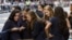 A group of Catholic school girls look at their phones as they wait on the route that Pope Francis will take later in the day near St. Patrick’s Cathedral in New York Sept. 24, 2015.