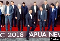 Leaders disperse after posing for a family photo ahead of the retreat session during the APEC Summit in Port Moresby, Papua New Guinea, Nov. 18, 2018.