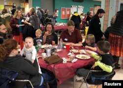 Furloughed government workers, contractors and their families attend a free community dinner donated from families and community organizations during the partial U.S. government shutdown at Montgomery Blair High School in Silver Spring, Md., Jan. 11, 2019.