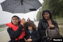 Residents are rescued by a boat from rising flood waters from Tropical Storm Harvey in east Houston, Texas, Aug. 28, 2017.