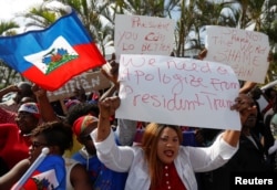 People protest against U.S. President Donald Trump's recent comments and tough stand on immigration near the Southern Boulevard bridge to Palm Beach near Mar-a-Lago, Florida, Jan. 15, 2018.