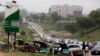 FILE - Cars queue up to buy fuel at a petrol station in Abuja, Nigeria, April 1, 2016. A series of bombings of pipelines and oil facilities have cut Nigeria's daily oil production of around two million barrels by as much as half.