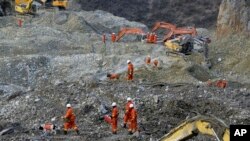 Tim pencari berusaha membongkar kira-kira dua juta meter kubik tanah longsor untuk mencari 79 buruh tambang yang masih hilang (30/3). 