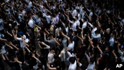 People display opened palm with five fingers, signifying the five demands of anti-government protesters during a march at Central district in Hong Kong, Wednesday, Oct. 2, 2019.