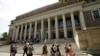 FILE - People walk past an entrance to Widener Library on the campus of Harvard University, in Cambridge, Mass., July 16, 2019.