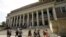 FILE - People walk past an entrance to Widener Library on the campus of Harvard University, in Cambridge, Mass., July 16, 2019.