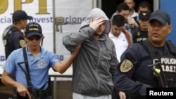 Police in Tegucicalpa escort one of five Syrians ordered jailed after they were found to have used stolen Greek passports to enter Honduras, Nov. 20, 2015.