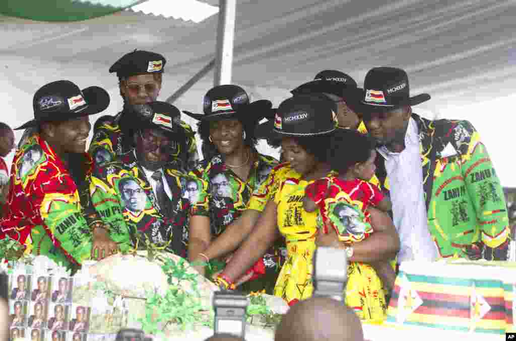 Zimbabwean President Robert Mugabe, center left, and his wife Grace, center are joined by his family as they cut the cake during his 93rd Birthday celebrations in Matopos on the outskirts of Bulawayo,&nbsp; Feb. 25, 2017.