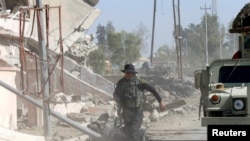 An Iraqi soldier runs through the city of Qaraqosh, as troops search for any Islamic State militants still in the area, near Mosul in Iraq, Oct. 30, 2016. 