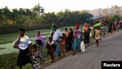 A group of Rohingya refugees, who fled last night from Myanmar by boat, walks toward a makeshift camp in Cox's Bazar, Bangladesh, Nov. 9, 2017.