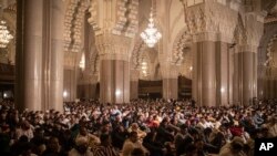 FILE - Worshippers gather to perform night prayers on the eve of Laylat-al-Qadr or Night of Power marking the 27th and holiest night of Islamic fasting month of Ramadan in Hassan II mosque in Casablanca, Morocco, April 28, 2022. 