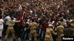 FILE - Demonstrators chant slogans and flash the Oromo protest gesture during Irreecha, the thanksgiving festival of the Oromo people, in Bishoftu town, Oromia region, Ethiopia. 