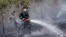 A member of the military works to contain a wildfire on a field in Indralaya, South Sumatra, Indonesia, Sept. 16, 2015.