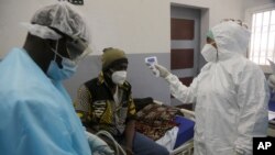  A health worker takes temperature of a COVID-19 patient at the Farcha provincial hospital in N'Djamena, Chad, April 30, 2021. 