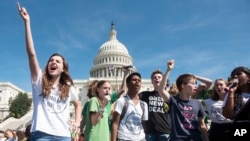FILE - People who spoke on stage, gather to rally the crowd at the end of the Climate Strike protest, Sept. 20, 2019, in Washington.