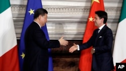 FILE - Chinese President Xi Jinping, left, and Italy's then-prime minister, shake hands following the signing of a memorandum in support of Beijing's Belt and Road Initiative, at Rome's Villa Madama, March 23, 2019.