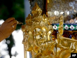 A Brahmin priest anoints Phra Phrom, the Thai interpretation of the Hindu god Brahma, with holy water during wellness and prosperity ceremony in Bangkok, Thailand, Friday, Sept. 4, 2015.