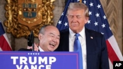 SoftBank Group CEO Masayoshi Son smiles with President-elect Donald Trump during a news conference at Mar-a-Lago, in Palm Beach, Florida, Dec. 16, 2024. 
