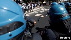 A refugee protests in the street after being forcibly removed from a building where he had been living, in central Rome, Italy, Aug. 23, 2017. 