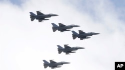 台灣空軍F-16戰機編隊在一個慶祝雙十節操演中飛越台北總統府上空。(2021年10月10日）