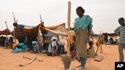 A woman prepares a mealat a Malian refugees camp in Chinegodar, western Niger, close to the Malian border, February 4, 2012.