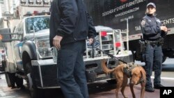 Emergency service personnel with a bomb-sniffing dog work outside the building that houses New York Governor Andrew Cuomo's office after a report of a suspicious package, Oct. 24, 2018, in New York.