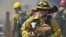 A firefighter rescues goats as flames from a wildfire envelope the area in Lower Lake, Calif.